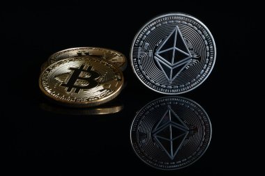 Siyah yansıtıcı arka planda kripto gümüş aethereum ve altın bitcoin