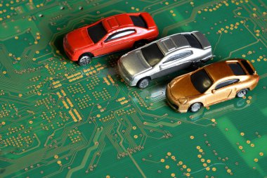 Elektronik panodaki entegre devreli oyuncak arabalar. Mikroçip ve yarı iletken sıkıntısı yeni araba sıkıntısı yaratıyor. Yarı iletken kıtlığı için kavramsal görüntü otomotiv endüstrisinin üretimini bozuyor.