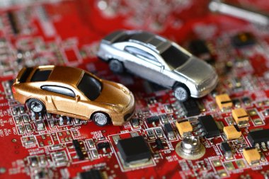 Elektronik panoda oyuncak arabalar ve mikroçip. Mikroçip ve yarı iletken sıkıntısı yeni araba sıkıntısı yaratıyor. Yarı iletken kıtlığı için kavramsal görüntü otomotiv endüstrisinin üretimini bozuyor.