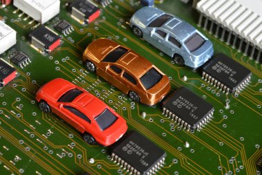 Elektronik panoda oyuncak arabalar ve mikroçip. Mikroçip ve yarı iletken sıkıntısı yeni araba sıkıntısı yaratıyor. Yarı iletken kıtlığı için kavramsal görüntü otomotiv endüstrisinin üretimini bozuyor.