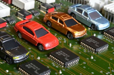 Elektronik panoda oyuncak arabalar ve mikroçip. Mikroçip ve yarı iletken sıkıntısı yeni araba sıkıntısı yaratıyor. Yarı iletken kıtlığı için kavramsal görüntü otomotiv endüstrisinin üretimini bozuyor.