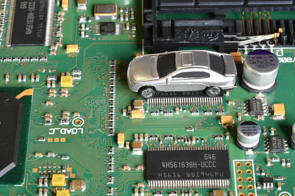 Elektronik panoda oyuncak arabalar ve mikroçip. Mikroçip ve yarı iletken sıkıntısı yeni araba sıkıntısı yaratıyor. Yarı iletken kıtlığı için kavramsal görüntü otomotiv endüstrisinin üretimini bozuyor.