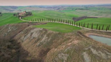 İtalya, Toskana - Mart 2022: Asciano yakınlarındaki Agriturismo Baccoleno 'ya giden Kıbrıs ağaçlarının hava manzarası. Val d 'Orcia, Siena Eyaleti. İtalya