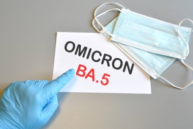 Mavi eldivenli doktorun eli, tıbbi koruma maskeli beyaz kağıt üzerinde 