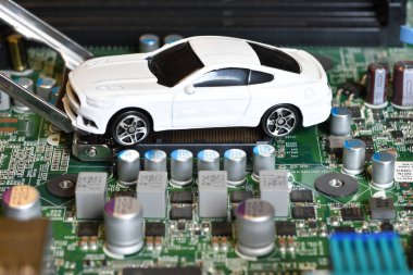 Elektronik panoda oyuncak arabalar ve mikroçip. Yarı iletken kıtlığı için kavramsal görüntü otomotiv endüstrisinin üretimini bozuyor