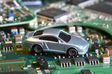 Elektronik panoda oyuncak arabalar ve mikroçip. Yarı iletken kıtlığı için kavramsal görüntü otomotiv endüstrisinin üretimini bozuyor