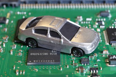 Elektronik panoda oyuncak arabalar ve mikroçip. Yarı iletken kıtlığı için kavramsal görüntü otomotiv endüstrisinin üretimini bozuyor