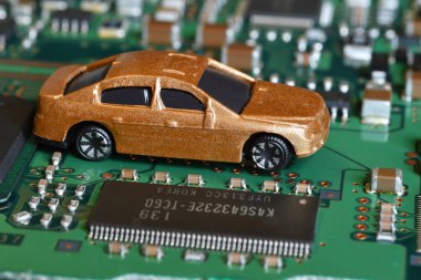 Elektronik panoda oyuncak arabalar ve mikroçip. Yarı iletken kıtlığı için kavramsal görüntü otomotiv endüstrisinin üretimini bozuyor
