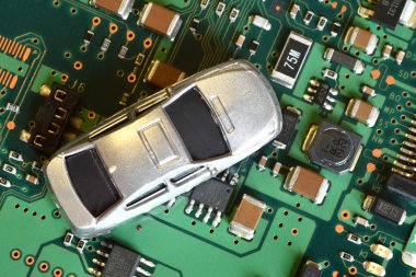 Toy cars on electronic board and microchip. Conceptual image for semiconductor shortage disrupting production of the automotive industry