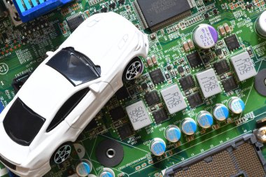 Elektronik panoda oyuncak arabalar ve mikroçip. Yarı iletken kıtlığı için kavramsal görüntü otomotiv endüstrisinin üretimini bozuyor