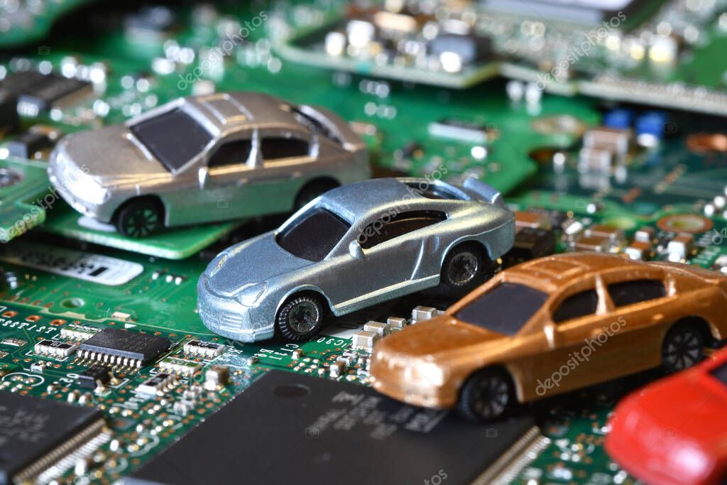 Toy cars on electronic board and microchip. Conceptual image for