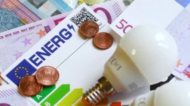 Enerji verimliliği derecelendirme tablosu, Avro banknotlarında ampuller, yakın plan. Enerji fiyatlarına zam kavramı.