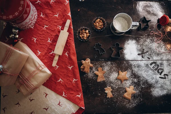 La nourriture de Noël. Biscuits maison au pain d'épice avec des ingrédients pour la cuisson de Noël et des ustensiles de cuisine sur la table noire, vue sur le dessus Images De Stock Libres De Droits