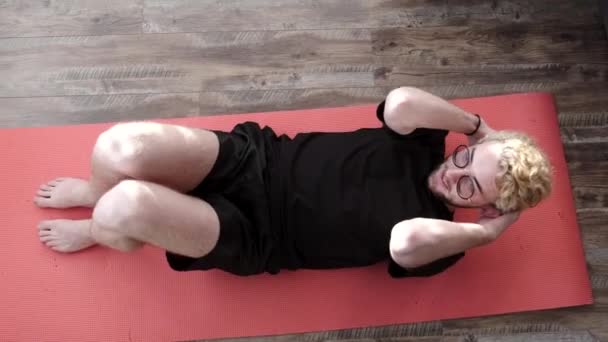 Młody fitness facet robi mięśnie brzucha ćwiczenia w domu — Wideo stockowe