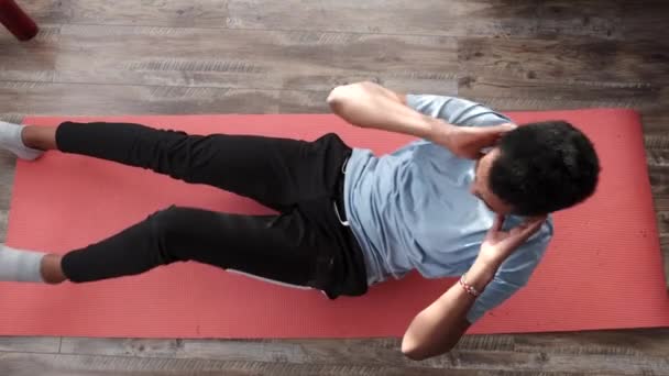 Νεαρός γυμναστής κάνει ασκήσεις κοιλιακών στο σπίτι — Αρχείο Βίντεο