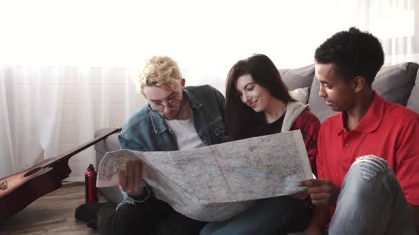 Group of diverse friends looking at map in the bright room — Stock Video