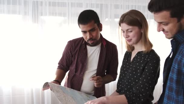 Diverse Freunde blicken im hellen Raum auf die Landkarte — Stockvideo
