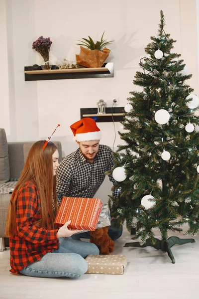 Couple mignon assis à la maison près de l'arbre de Noël — Photo