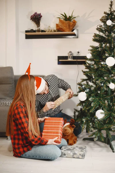 Couple mignon assis à la maison près de l'arbre de Noël — Photo