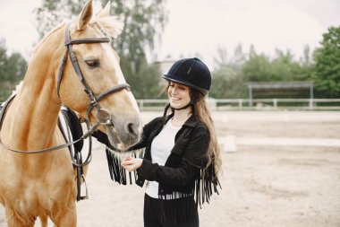 Portrait of riding horse with woman in black helmet