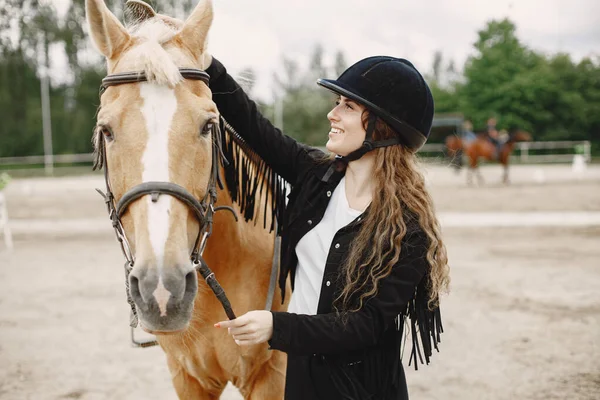 黒のヘルメットの女性と乗馬の肖像画 — ストック写真
