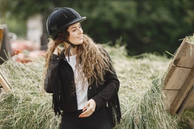 Portrait of rider woman in a black helmet on a farm