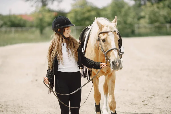 黒のヘルメットの女性と乗馬の肖像画 — ストック写真