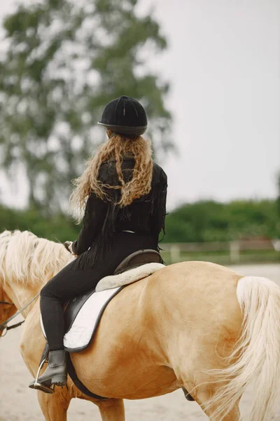 Retrato de mujer en casco negro montando un caballo marrón — Foto de Stock