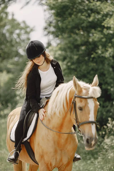Portrait of woman in black helmet riding a brown horse — Foto Stock