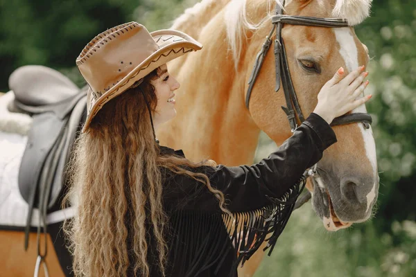 Retrato de mujer en sombrero de cuero marrón con un caballo — Foto de Stock