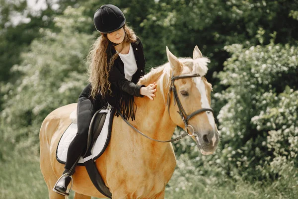 Portrait of woman in black helmet riding a brown horse — Foto Stock