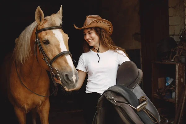 Portrait of rider woman with a brown horse in a stable — Foto Stock
