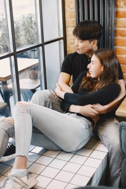 Asian young man hugging his caucasian girlfriend when they are s