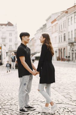 Two lovers holding a hands on the streets of the old city during