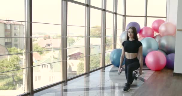 Frau macht Übung mit Kurzhanteln im Fitnessstudio — Stockvideo