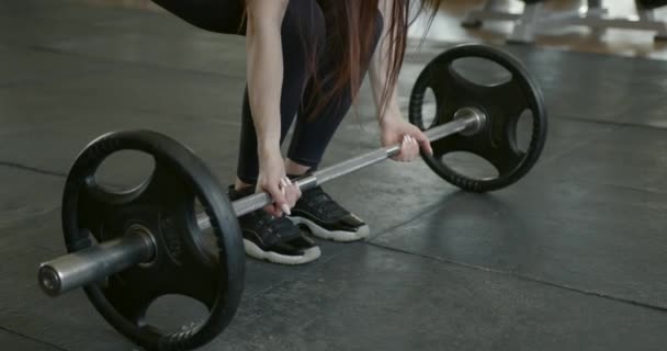 Female athlete doing squats with barbell at gym — Stockvideo