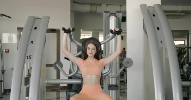Determined young woman working out on machine — Stock video