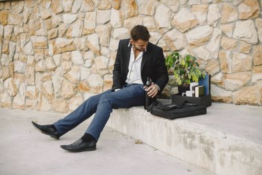 Upset fired european man getting drunk outside