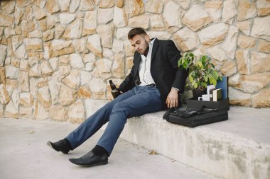 Upset fired european man getting drunk outside