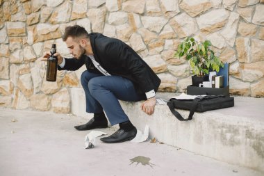 Upset fired european man getting drunk outside