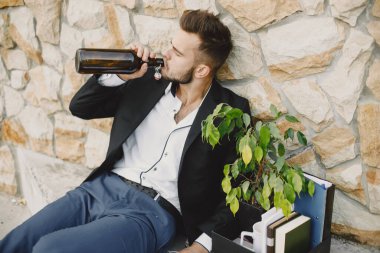 Upset fired european man getting drunk outside