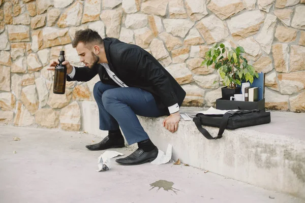 Upset fired european man getting drunk outside