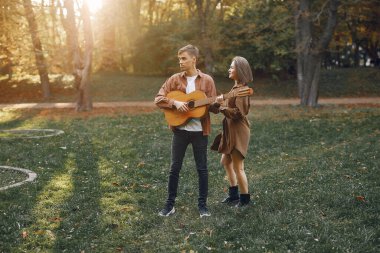 Güzel bir çift sonbahar parkında vakit geçirir.