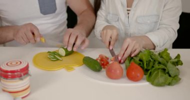 Gülümseyen karı koca mutfakta yemek pişiriyor.