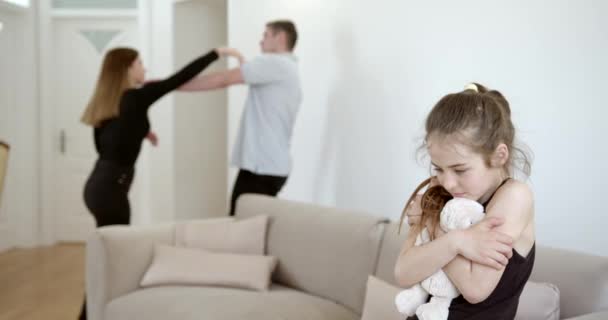 Sorglig liten flicka och hennes grälande föräldrar hemma — Stockvideo