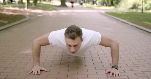 Hombre atlético haciendo flexiones en el parque de verano — Vídeo de stock