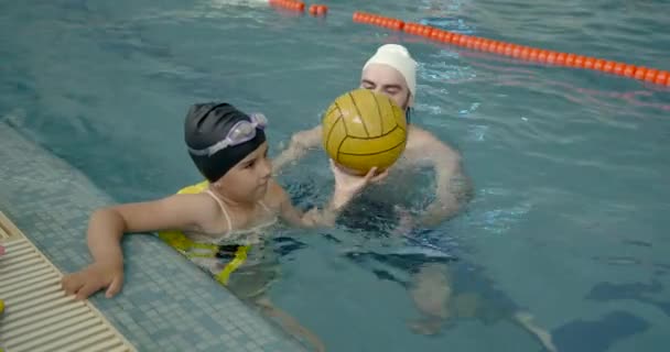 Flicka lära sig simma med tränare på fritidscenter — Stockvideo
