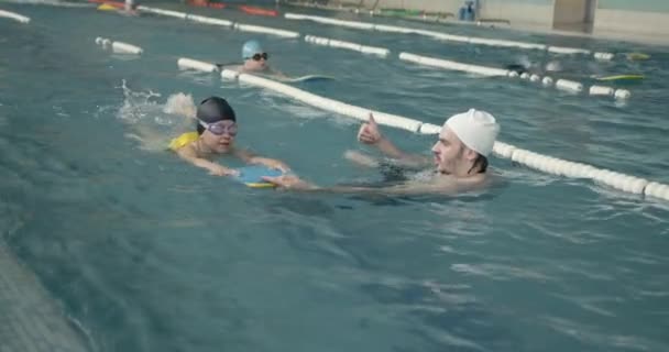 Mädchen lernt Schwimmen mit Trainer im Freizeitzentrum — Stockvideo