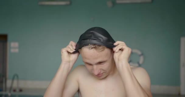 Portrait of a swimmer putting on his goggles in the swimming pool — Stock Video