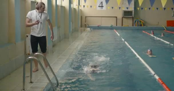 男游泳教练经过游泳池 — 图库视频影像